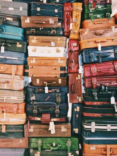 large pile of suitcases of a wide variety of colors