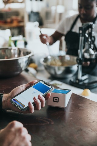 person using cellphone to pay at coffee shop