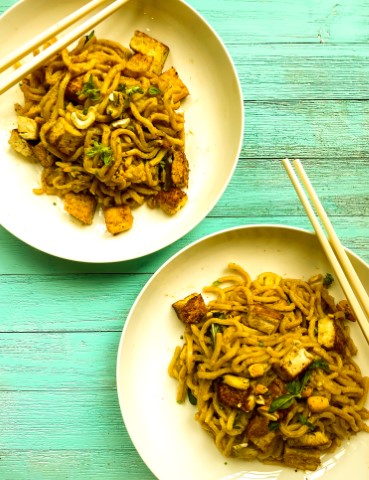 two plates with tofu ramen and chopstick sitting on one plate