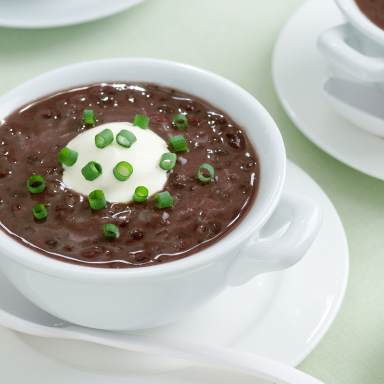 cooked black beans in white bowl on white plate