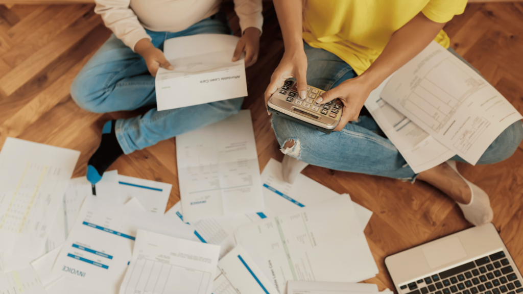 two people with a pile of bills and papers