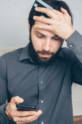 man distressed looking at cell phone