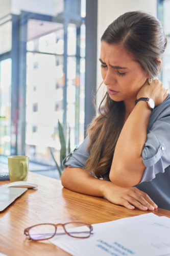 woman rubbing her neck stressed