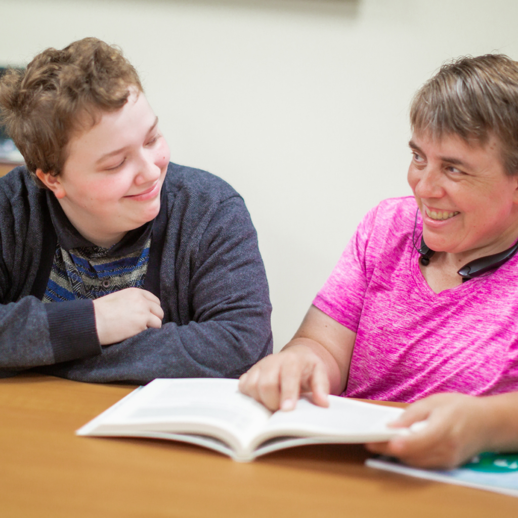 mom reading through book with daughter