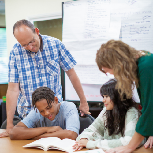 group of people looking at a book